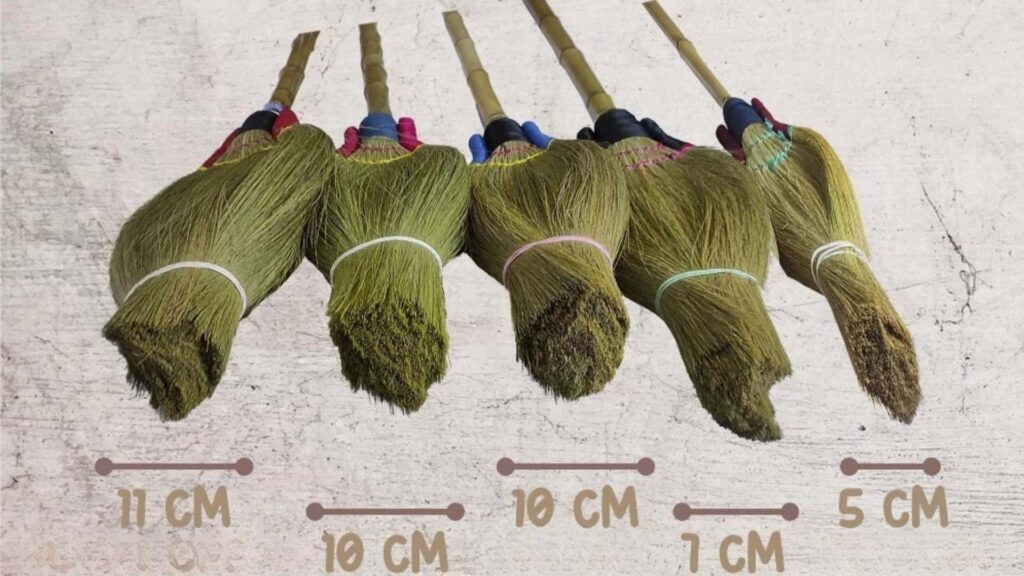 Grass broom builders preparing brooms for export